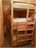 Children's bedroom area with 3 bunk beds, wooden furniture and panelling, window facing outside