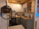 Modern studio kitchenette with oven, microwave, and cooktop.