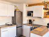 Cuisine ouverte tout équipée, moderne et fonctionnelle. Avec un îlot central et un luminaire suspendu