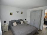 Bright bedroom with double bed, window and curtains