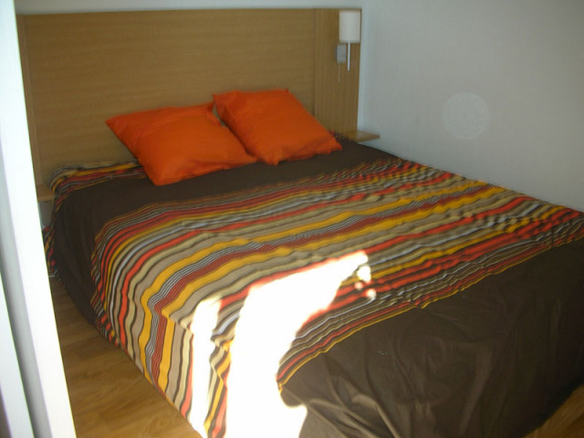 Chambre à coucher lumineuse avec lit double, ameublement bois, parquet au sol Chambre à coucher lumineuse avec lit double, ameublement bois, parquet au sol