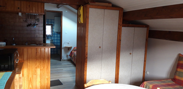 Séjour avec coin cuisine carrelé, espace de rangement, table à manger, passage vers salle de bains, parquet au sol Séjour avec coin cuisine carrelé, espace de rangement, table à manger, passage vers salle de bains, parquet au sol