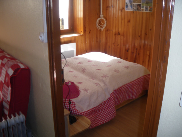 Chambre à coucher lumineuse avec lit double, ameublement bois, parquet au sol, fenêtre Chambre à coucher lumineuse avec lit double, ameublement bois, parquet au sol, fenêtre