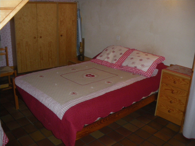 Chambre à coucher avec lit double, ameublement bois, sol carrelé Chambre à coucher avec lit double, ameublement bois, sol carrelé