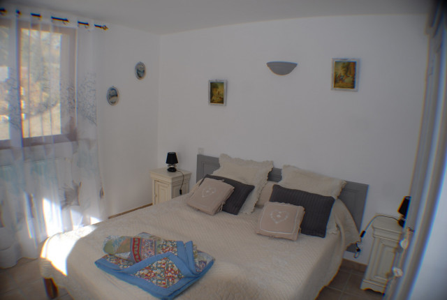 Bright bedroom with double bed, window and curtains