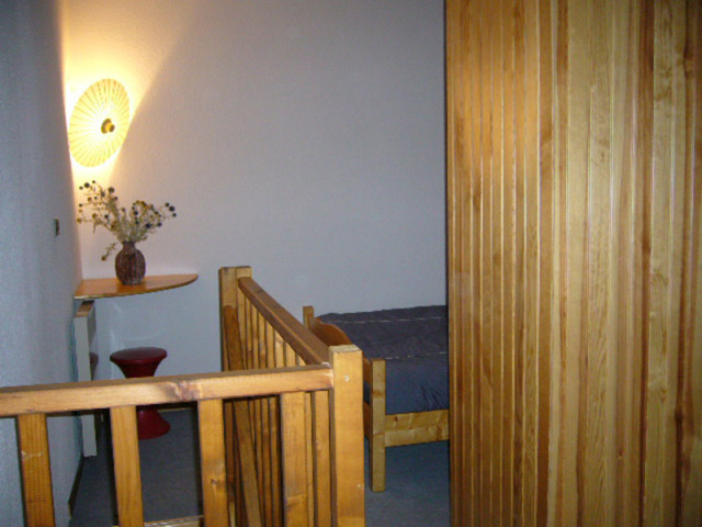 Bedroom corner with single bed, wooden furniture, panelling