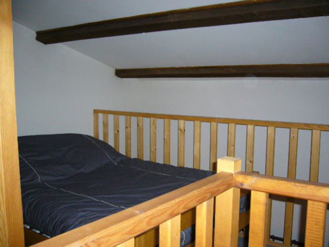 Attic bedroom with double bed and wood railing