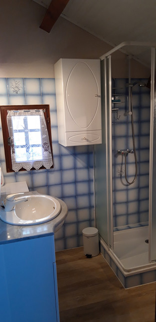 Tiled bathroom with shower tray, sink, parquet flooring and window - © M Miserandini Tiled bathroom with shower tray, sink, parquet flooring and window