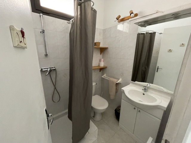 Bright tiled bathroom with shower tray, window