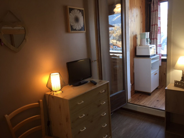 Séjour de studio avec TV, ameublement bois, porte-fenêtre donnant sur pièce supplémentaire - © Pellissier A Séjour de studio avec TV, ameublement bois, porte-fenêtre donnant sur pièce supplémentaire