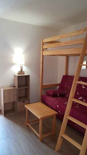 Espace salon avec canapé et lit en mezzanine, ameublement bois - © Pellissier A Espace salon avec canapé et lit en mezzanine, ameublement bois