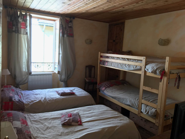 Bright bedroom with bunk beds and two single beds, window, wooden furniture
