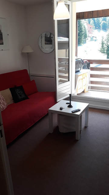 Bright studio living room, sofa, coffee table, French doors opening onto a balcony with a view of the station - © Rovera Bright studio living room, sofa, coffee table, French doors opening onto a balcony with a view of the station