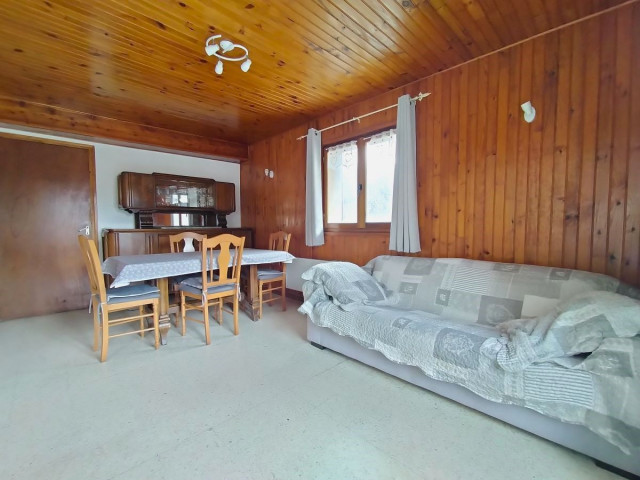 Bright apartment living room with dining table, sofa, wooden furniture, window