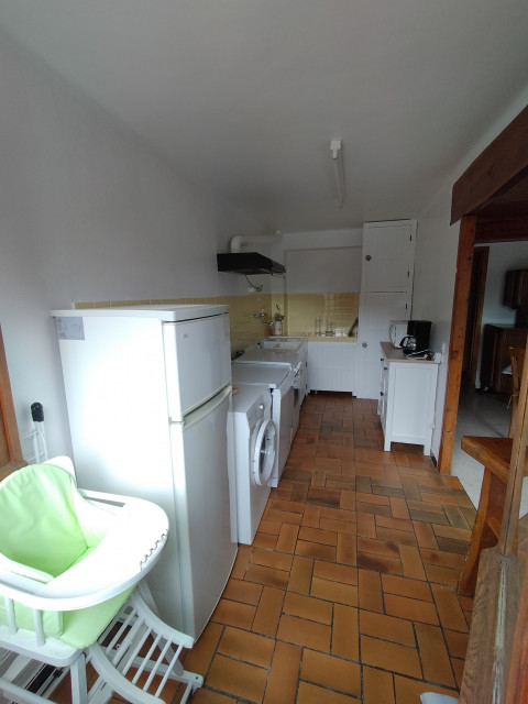 Coin cuisine en couloir avec machine à laver, gazinière, évier