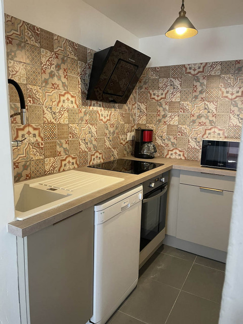 Modern kitchenette with electric hobs and dishwasher