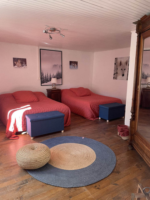 Bright bedroom with double bed and single bed, mirror, wooden furniture