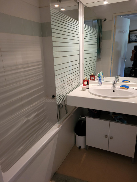 Salle de bains avec baignoire, évier, miroir et meuble de rangement Salle de bains avec baignoire, évier, miroir et meuble de rangement