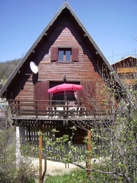 chalet en bois ensoleillé avec terrasse, fenêtres