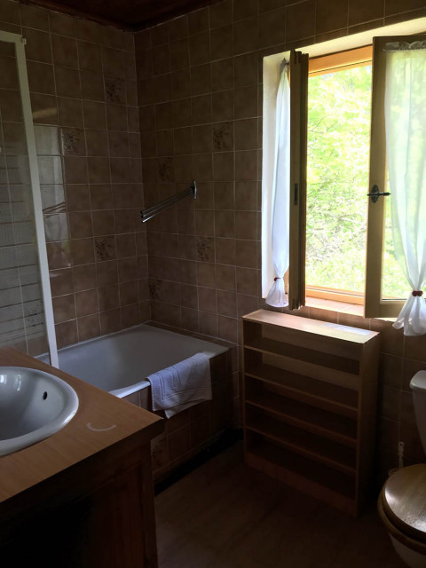 Tiled bathroom with bathtub, sink, wooden furniture, window - © S Pellissier Tiled bathroom with bathtub, sink, wooden furniture, window