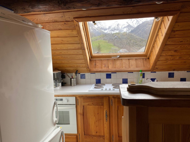 Coin cuisine sous combles tout équipée, plaques électriques, vue sur les montagnes par fenêtre - © Pellissier N Coin cuisine sous combles tout équipée, plaques électriques, vue sur les montagnes par fenêtre