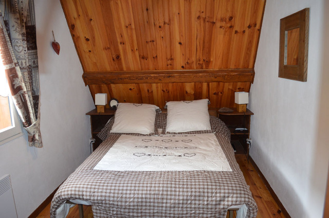 chambre à coucher lumineuse sous comble avec lit double et fenêtre