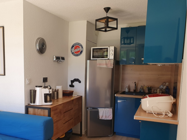 Living area with sofa bed and coffee table, fully equipped kitchen area