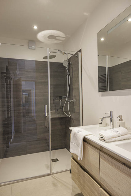 Bathroom, large shower tray, sink, wood furniture and parquet flooring