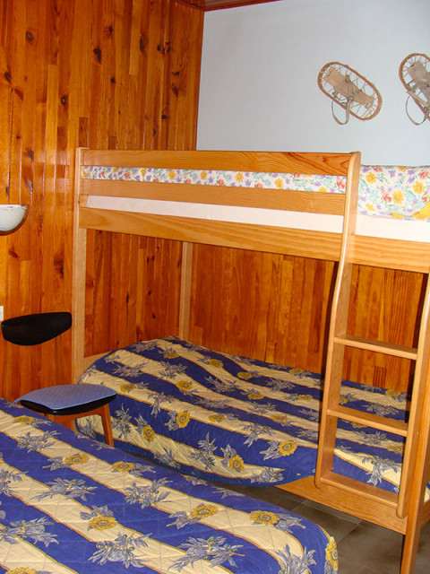 Children's bedroom with wooden furniture and panelling, bunk beds and single bed