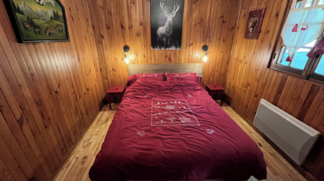 Camera con letto matrimoniale, interno in legno. Radiatore a muro e finestra con vista sulle montagne - © Estelle Rouhette Camera con letto matrimoniale, interno in legno. Radiatore a muro e finestra con vista sulle montagne