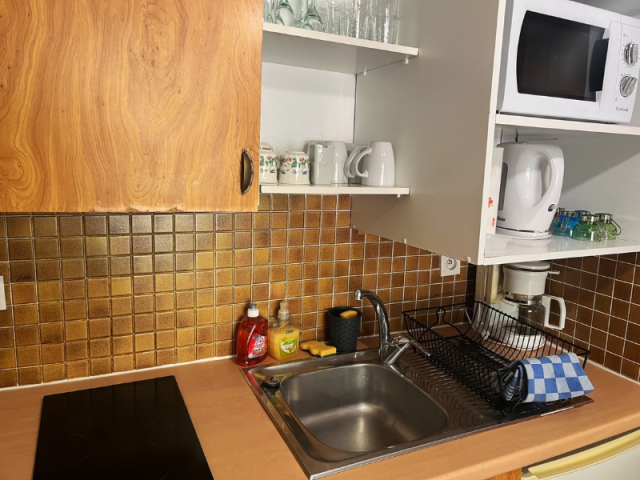 Angolo cottura con piano cottura, forno a microonde, macchina per il caffè e bollitore, mobili in legno - © F.Ottevent Angolo cottura con piano cottura, forno a microonde, macchina per il caffè e bollitore, mobili in legno