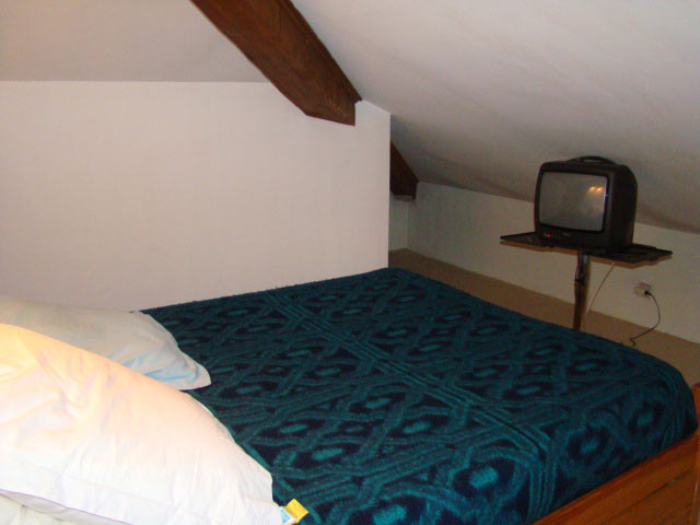 Attic bedroom with double bed, TV, wooden furniture