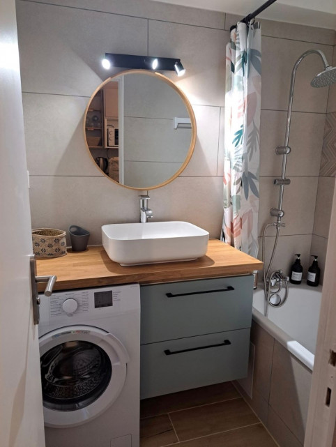 Studio bathroom: bathtub, sink, mirror, washing machine