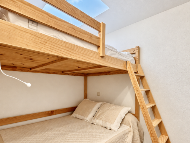 Chambre avec un vélux et des lit en bois. Un lit double et un lit en mezzanine. - © C.Travaglini Chambre avec un vélux et des lit en bois. Un lit double et un lit en mezzanine.